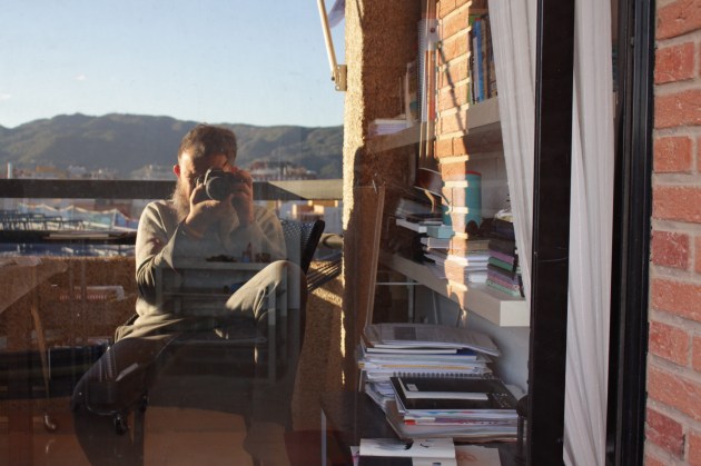 artista antónReina haciéndose una foto con el reflejo del cristal de su balcón